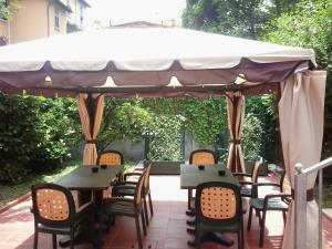 米兰尼萨酒店的露台设有天篷下的桌椅