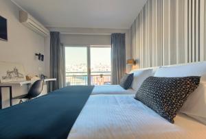 马塔罗新科隆酒店的一间卧室设有一张大床和大窗户