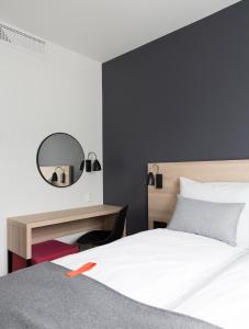 卑尔根Citybox Bergen City的一间卧室配有一张床、一张书桌和一面镜子