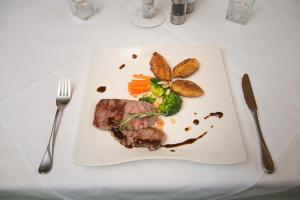 达米尔斯Hotel Hertehof的桌上的肉和蔬菜白盘
