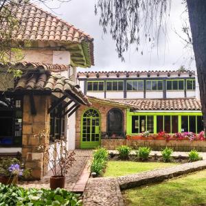 瓜斯卡果园咖啡旅馆的一座带绿门和院子的房子