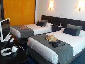 阿雷西费米拉玛酒店 的酒店客房,设有两张床,上面有帽子
