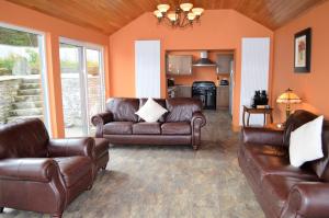 KamesTaigh na Mara的一间带真皮沙发的客厅和一间厨房