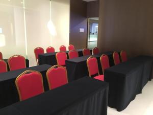 南宁锦江之星南宁朝阳广场人民公园店的一间会议室,配有黑桌和红色椅子
