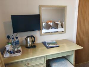 洛亨黑德洛亨黑德酒店的一张桌子,里面配有电视和镜子