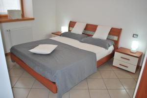 Castel CondinoCadari' Appartamenti的一间卧室配有一张床和一个白色床头柜