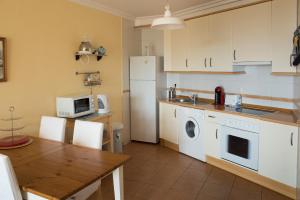 厄尔梅达诺Sotavento的厨房配有桌子和白色冰箱。