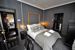 英雄港Angra Bed & Breakfast的一间卧室设有一张大床和黑色的墙壁