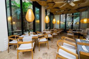 卡塔赫纳卡塔赫纳莫维奇酒店的餐厅设有木桌和椅子以及大窗户。