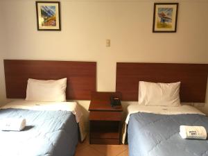 瓦拉斯邦德旅馆的酒店客房设有两张床和一张桌子。