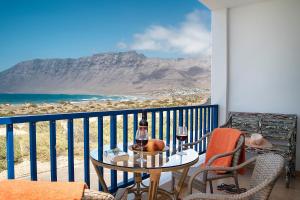 法马拉Famara Views的阳台配有桌子和两杯葡萄酒