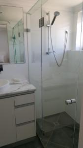 玛志洛榕树塔酒店的一间带玻璃淋浴间和水槽的浴室