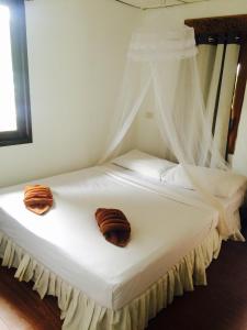 皮皮岛热带花园简易别墅度假村的一张白色的床,上面有两个枕头