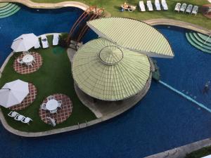 安吉利斯野兰花度假村的享有带遮阳伞和桌子的游泳池的顶部景致