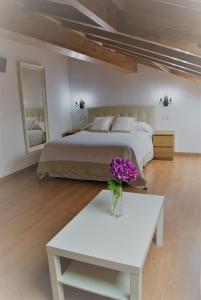 帕阿斯德兰斯El Rincon del Cuera的一间卧室配有一张床和一张花瓶桌子