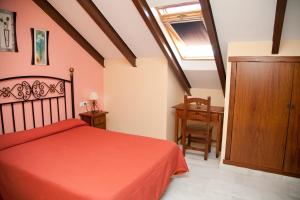 圣胡安德尔普埃尔托尼扎旅馆的一间卧室配有红色的床和木制橱柜