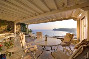 埃利亚海滩Mykonian Dianthus的一个带桌椅的庭院和大海