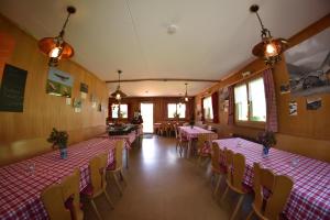 StrassbergBerggasthaus-Strassberg的用餐室配有桌椅和粉红色的桌布