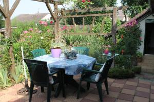 诺让莱罗特鲁Chambre d'Hôtes "Orchidees"的花园配有桌椅和凉亭