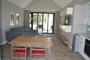 SimondiumPearl Valley Suite 504的厨房以及带木桌和椅子的客厅。