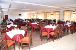 ZiwayHaile Resort Ziway Batu的用餐室配有桌椅和红色餐巾