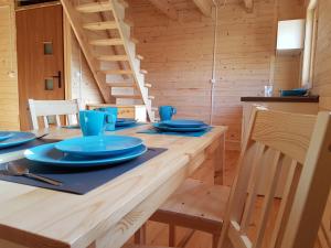 米兹多洛杰Domki Pajka的一间用餐室,配有一张带蓝色菜肴的桌子