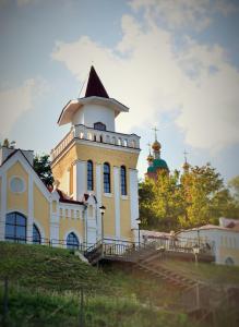 SarapulHotel Staraya Bashnya的山顶上一座有塔的建筑