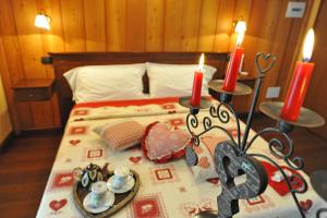 瓦托内切兰西安帕奎亚住宿加早餐旅馆的一间卧室,配有一张带两个蜡烛和一盘食物的床
