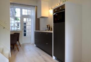 弗拉讷克Huisje aan de gracht的厨房配有黑色冰箱和桌子