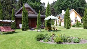 里加Forest Edge Lodge的院子里带野餐桌和雨伞的房子