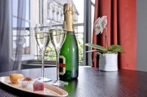 雅尔纳克立格罗酒店的一瓶香槟和一张桌子上的两杯酒
