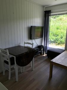 MeråkerHybeltunet的客厅配有桌子和电视