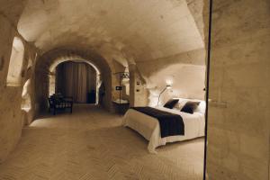 马泰拉帕拉索托酒庄民宿的一间位于隧道内的卧室,配有一张大床