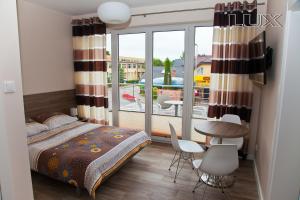 达洛科达罗科假日旅馆的一间卧室配有一张床,阳台配有桌椅