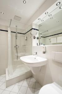 施特兰德Strandhotel Strande的白色的浴室设有水槽和淋浴。