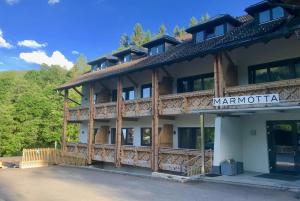 上柯尼希山麓米尔巴赫Marmotta Alpin hotel的一座有军阀酒店标志的建筑