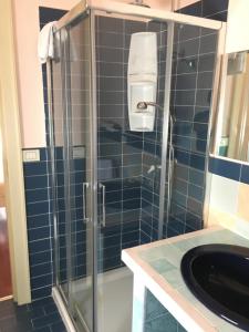 波蒂奇Gioviale Rooms的浴室设有玻璃淋浴间,铺有蓝色瓷砖