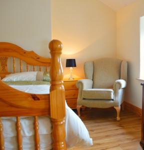 卡尔达夫Biddys Cottage的一间卧室配有一张床和一把椅子