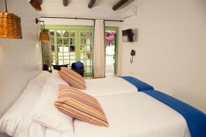 亚伊萨Hotelito La Era B&B的卧室配有白色的床和两个枕头