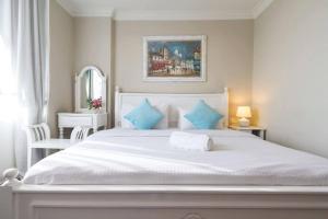 峇六拜世纪海湾住宅的白色卧室配有白色大床和蓝色枕头