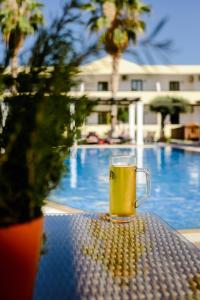 佩基罗德佩克斯度假村公寓式酒店的坐在游泳池畔的桌子上喝杯啤酒