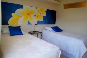 JinotepeLa Residencia Inn的墙上画画的房间里设有两张床