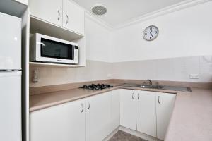 豪勋爵岛洛希提公寓的厨房配有白色橱柜和微波炉