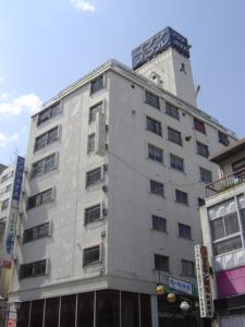 高崎高崎前基广场酒店的一座高大的白色建筑,上面有钟