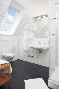 利普施塔特Parkhotel Lippstadt的带淋浴、盥洗盆和卫生间的浴室