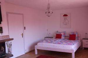 菲林根-施文宁根Lila Villa Schwenningen的一间卧室配有一张带红色枕头的床