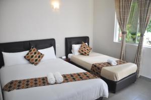 丹绒鲁日落湾旅馆的酒店客房设有两张床和窗户。