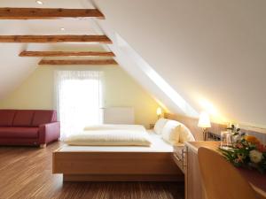 加姆利茨维恩古特什科夫奥利吉诺旅馆的一间卧室配有一张床和一张红色的沙发