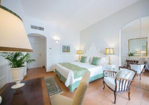 米诺利罗马纳别墅Spa酒店的卧室配有一张床和一张桌子及椅子