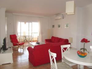 内尔哈Carabeo 2000 3.1的客厅配有红色的沙发和桌子